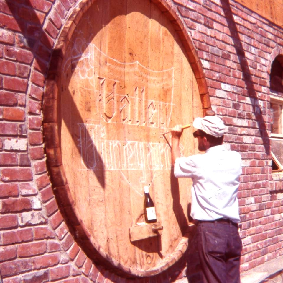 Valley Vineyards founder hand-carving the original sign — circa 1970
